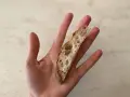 Una mano sostiene una rebanada de pan artesanal, perfecta para el primer pan para bebés.