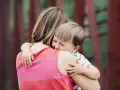 Un niño llora aferrado a su madre. A veces, los bebés rechazan a algunas personas por instinto o por no sentirse seguros.