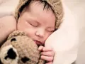 Bebé dormido con gorro de oso. ¿Cómo despertar a un bebé para que coma?