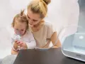 Madre consuela a su hija con bronquitis espástica mientras usa un nebulizador.