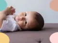 Un bebé de 6 meses, con ojos curiosos, parece estar soñando despierto mientras descansa sobre un sofá.