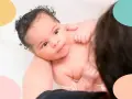 Un bebé de 1 mes disfruta de sus tomas nocturnas en la bañera, con burbujas y el cariño de sus padres.