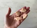 Trozo de salmón desmenuzado en una mano, ideal para saber cuándo dar salmón a un bebé.