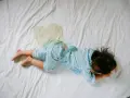 Niño en cama con mancha de orina. Buscando enuresis nocturna infantil remedios naturales para ayudarle.