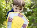Niño con escudo de juguete, listo para la aventura. ¡Jugar al aire libre ayuda a subir defensas niños!