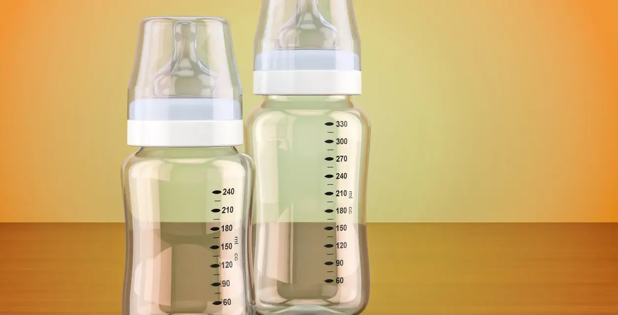Dos biberones, uno de cristal o plástico más pequeño y otro más grande, con marcas de medición.
