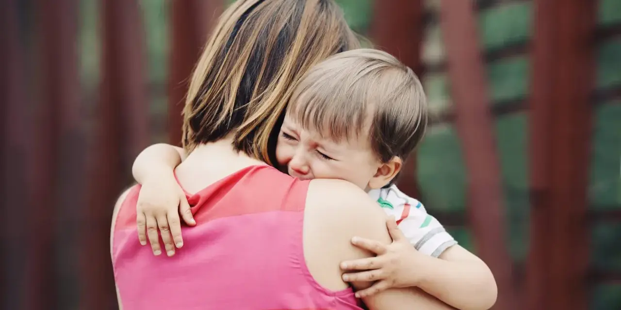 Un niño llora aferrado a su madre. A veces, los bebés rechazan a algunas personas por instinto o por no sentirse seguros.