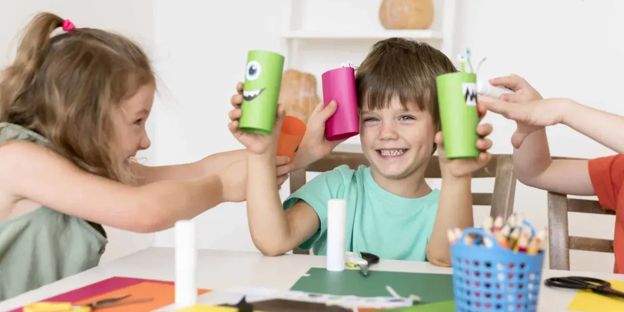 Niños creando monstruos de cartón, una actividad que fomenta la psicomotricidad infantil.