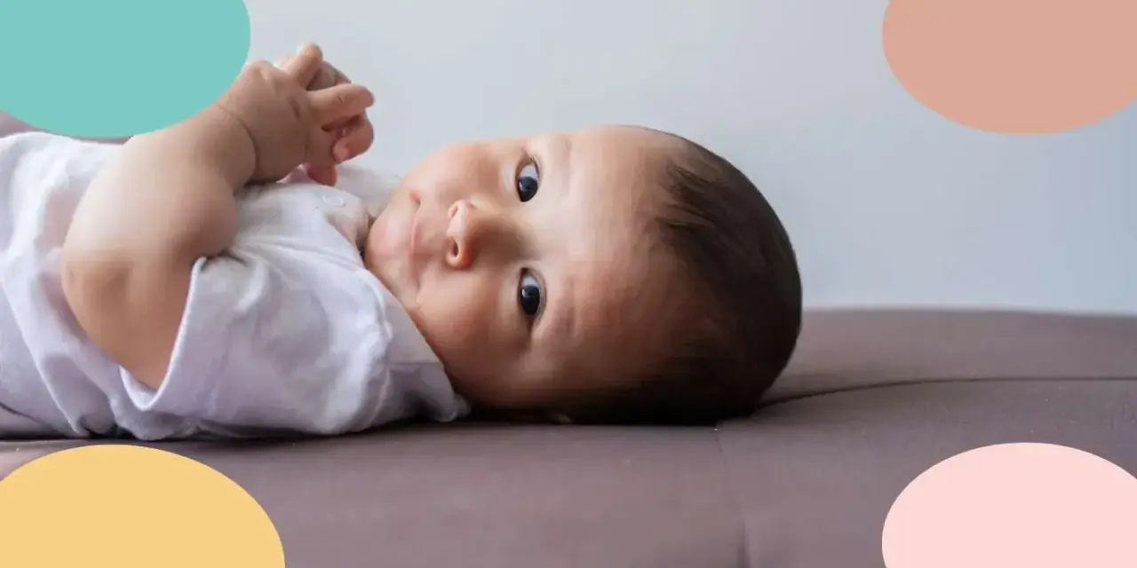 Un bebé de 6 meses, con ojos curiosos, parece estar soñando despierto mientras descansa sobre un sofá.