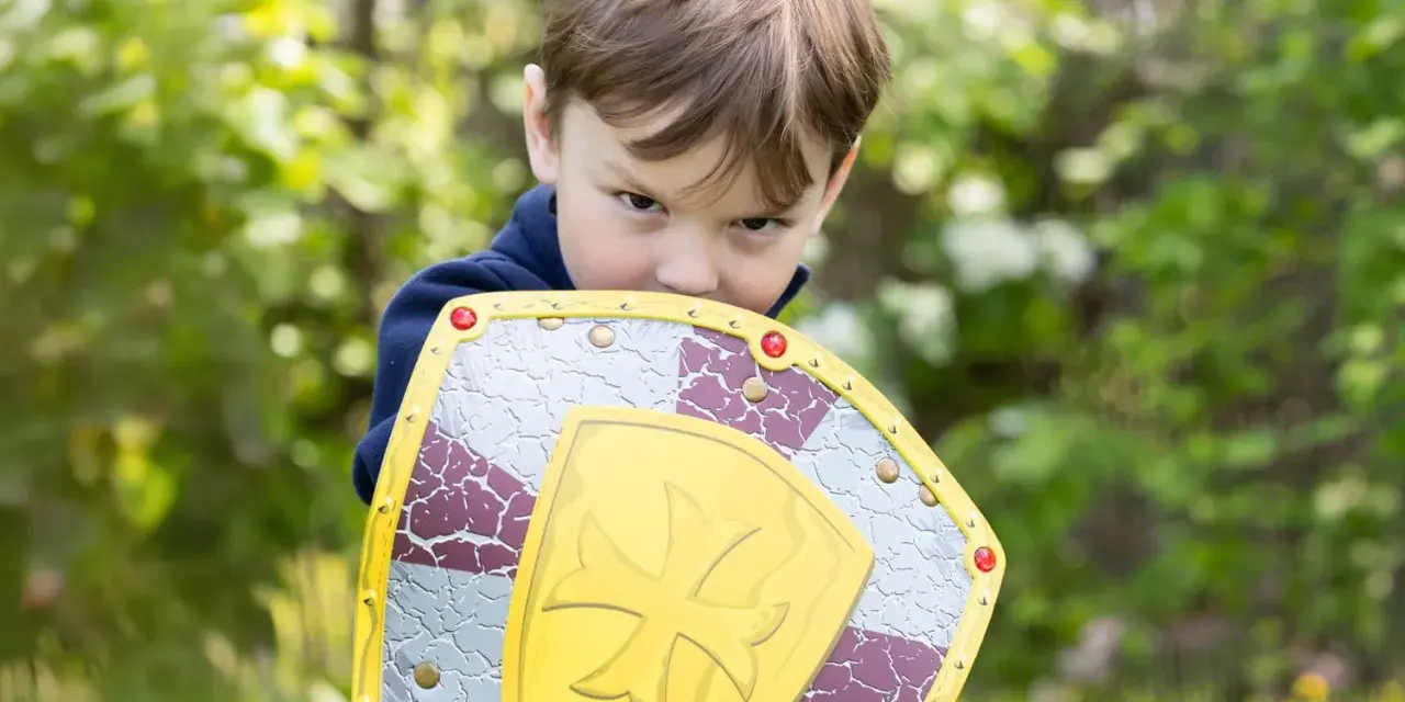 Niño con escudo de juguete, listo para la aventura. ¡Jugar al aire libre ayuda a subir defensas niños!
