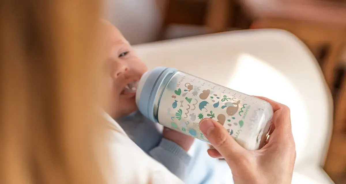 Bebé de 5 meses tomando biberón. La cantidad de biberones que toma un bebé de 5 meses varía, pero este parece disfrutar el suyo.