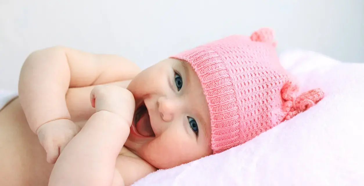 Bebé sonriente con gorro rosa, su nombre es Astrid.