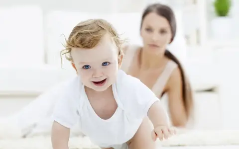 Bebé sonriente gateando, con su madre observando. Una escena tierna para estimular el gateo.