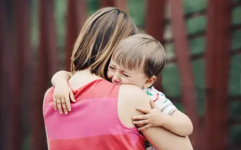 Un niño llora aferrado a su madre. A veces, los bebés rechazan a algunas personas por instinto o por no sentirse seguros.