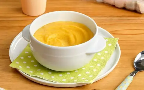 Puré amarillo en un cuenco blanco, ideal para saber qué pescado puede comer un bebé de 6 meses.