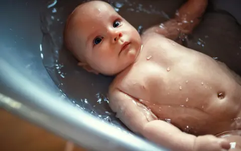 Un bebé disfruta de un baño relajante en la bañera. Se puede bañar a un bebé después de comer para una higiene completa.