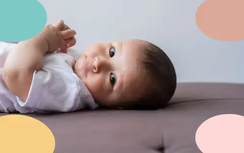 Un bebé de 6 meses, con ojos curiosos, parece estar soñando despierto mientras descansa sobre un sofá.