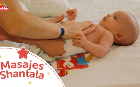 Manos adultas realizan un masaje Shantala a un bebé, fomentando el vínculo y el bienestar.