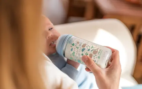 Bebé de 5 meses tomando biberón. La cantidad de biberones que toma un bebé de 5 meses varía, pero este parece disfrutar el suyo.