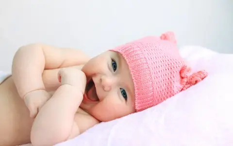 Bebé sonriente con gorro rosa, su nombre es Astrid.