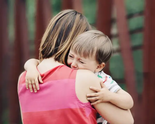 Un niño llora aferrado a su madre. A veces, los bebés rechazan a algunas personas por instinto o por no sentirse seguros.