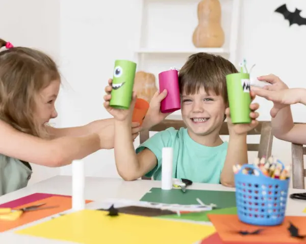 Niños creando monstruos de cartón, una actividad que fomenta la psicomotricidad infantil.