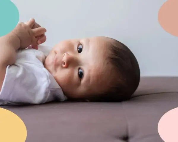 Un bebé de 6 meses, con ojos curiosos, parece estar soñando despierto mientras descansa sobre un sofá.