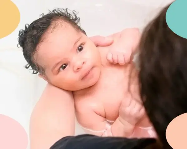 Un bebé de 1 mes disfruta de sus tomas nocturnas en la bañera, con burbujas y el cariño de sus padres.
