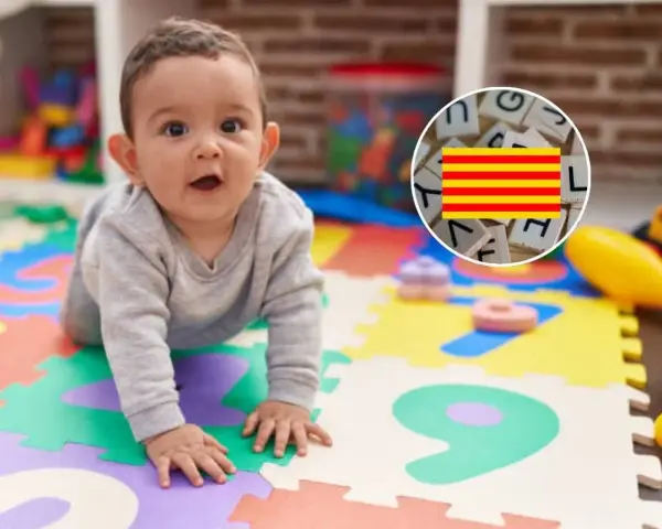 Bebé gateando sobre un tapete de números, con un círculo que muestra letras y la bandera de Cataluña.