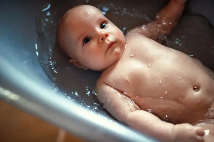 Un bebé disfruta de un baño relajante en la bañera. Se puede bañar a un bebé después de comer para una higiene completa.