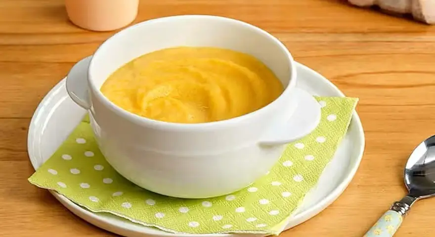Puré amarillo en un cuenco blanco, ideal para saber qué pescado puede comer un bebé de 6 meses.