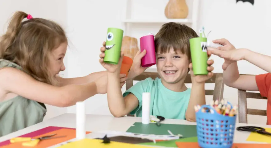 Niños creando monstruos de cartón, una actividad que fomenta la psicomotricidad infantil.