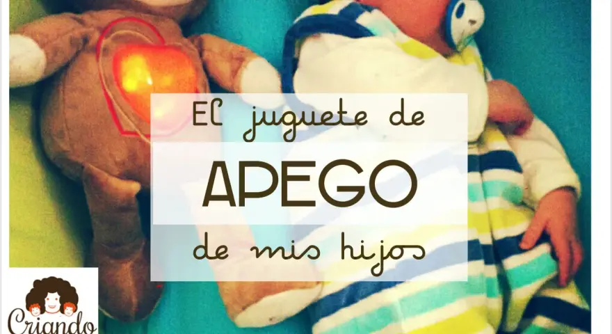 Un peluche con un corazón brillante, un bebé envuelto en mantas a rayas. El juguete de apego favorito de mis hijos.