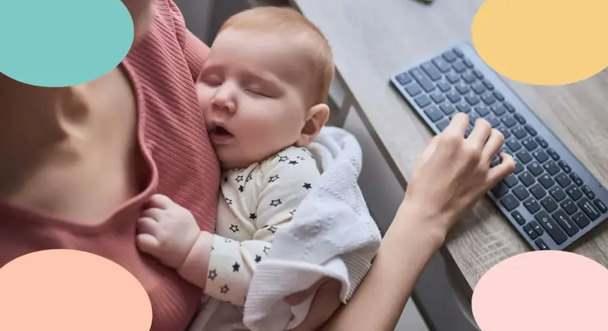Mi bebe solo duerme en brazos mientras trabajo. Un tierno bebé duerme plácidamente en brazos, envuelto en una manta, mientras una mano teclea en un ordenador.