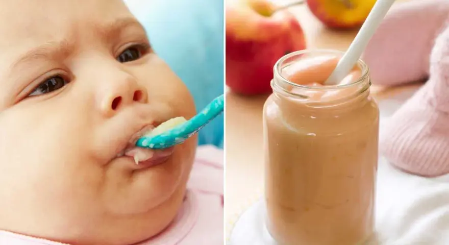 Bebé de 4 meses probando su primera fruta. Puré de manzana en un tarro y una cuchara.
