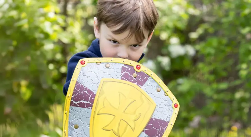 Niño con escudo de juguete, listo para la aventura. ¡Jugar al aire libre ayuda a subir defensas niños!
