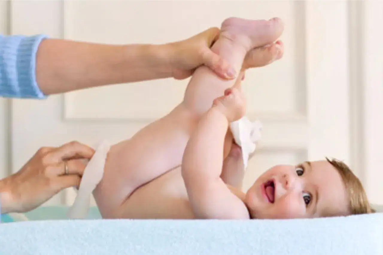 Un beb&eacute; sonriente es cambiado. La pregunta de cu&aacute;ntos pa&ntilde;ales gasta un beb&eacute; al d&iacute;a es una preocupaci&oacute;n com&uacute;n.