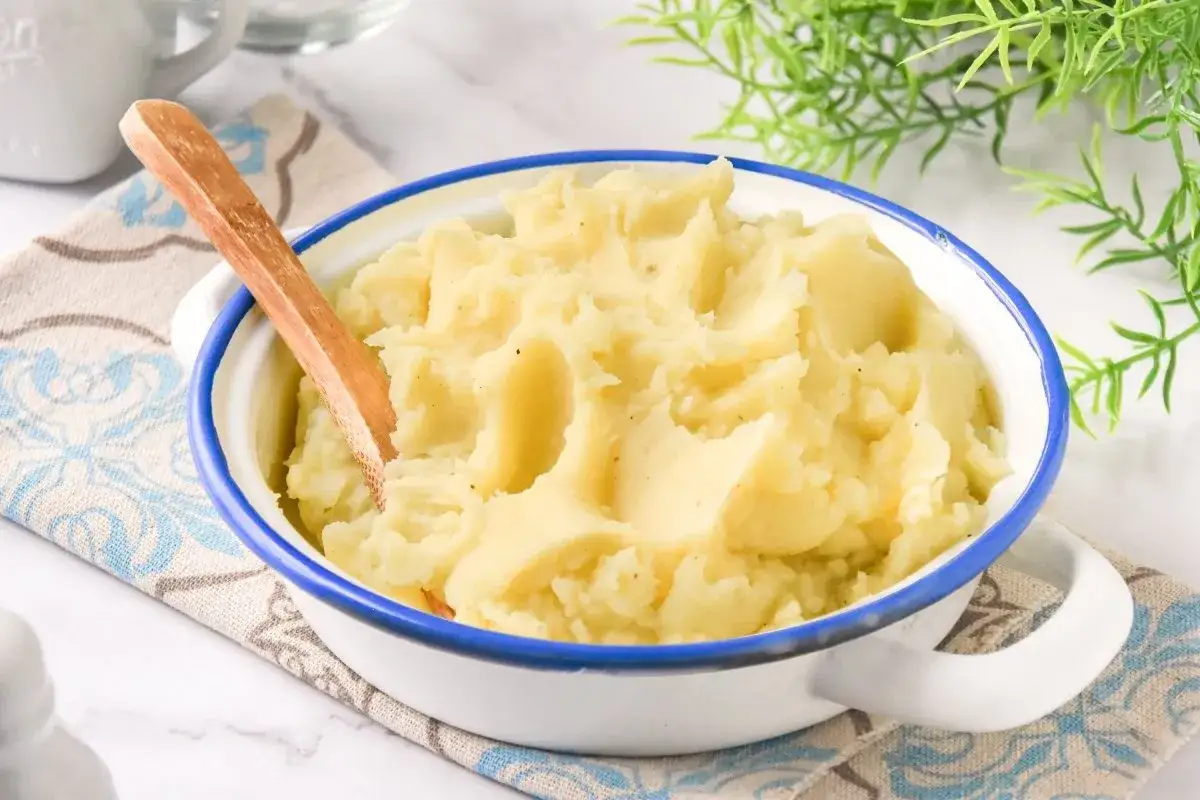 Pur&eacute; de patatas cremoso en un cuenco blanco con borde azul. &iquest;Cuanto tiempo puedo guardar un pur&eacute; en la nevera?