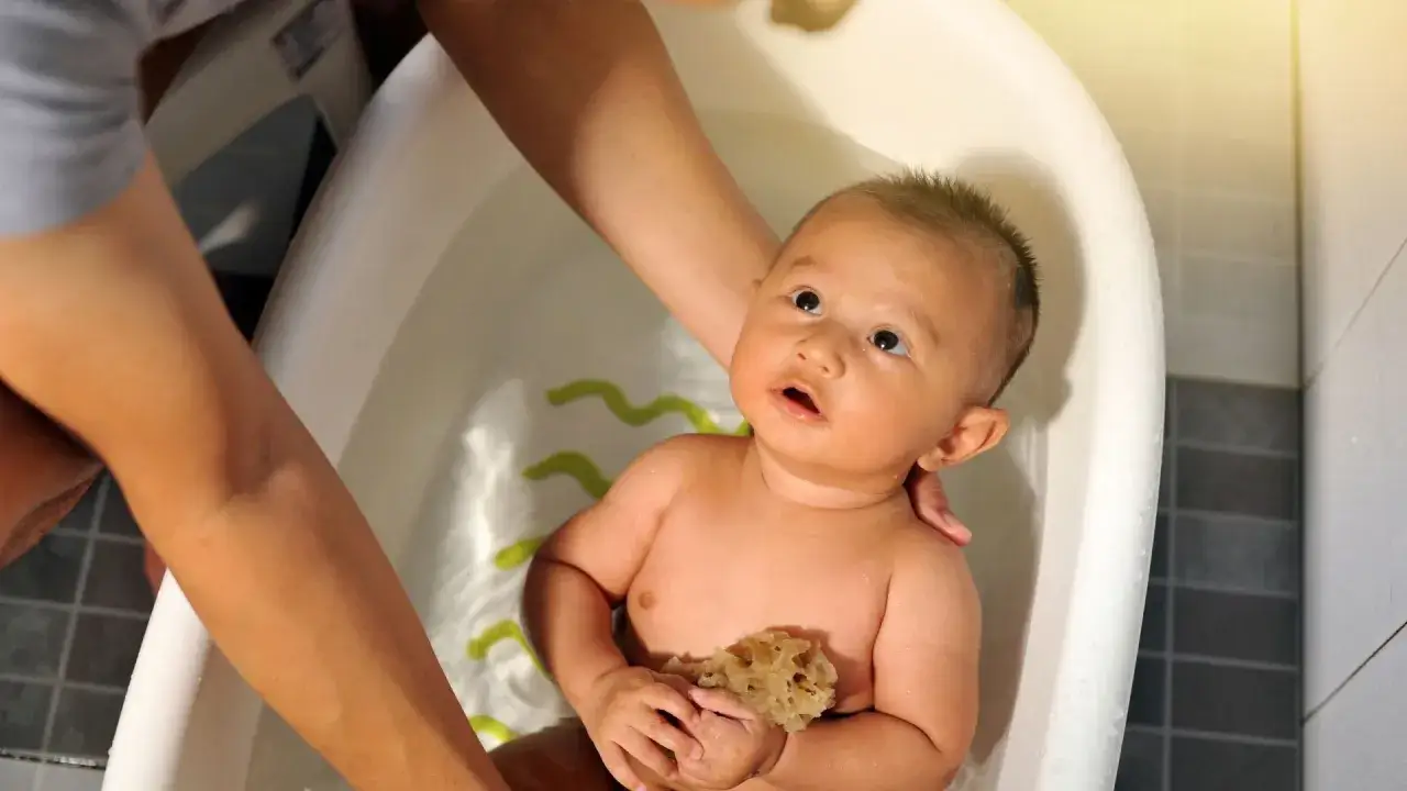 Beb&eacute; en ba&ntilde;era, asegurando la temperatura del agua para un ba&ntilde;o seguro y divertido.