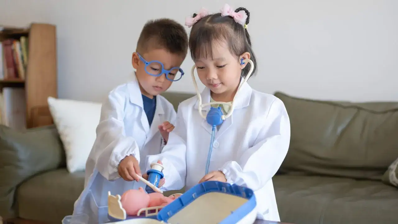 Ni&ntilde;os jugando a ser doctores, usando batas blancas y estetoscopios. Estos juegos de representaci&oacute;n fomentan la imaginaci&oacute;n y el aprendizaje.