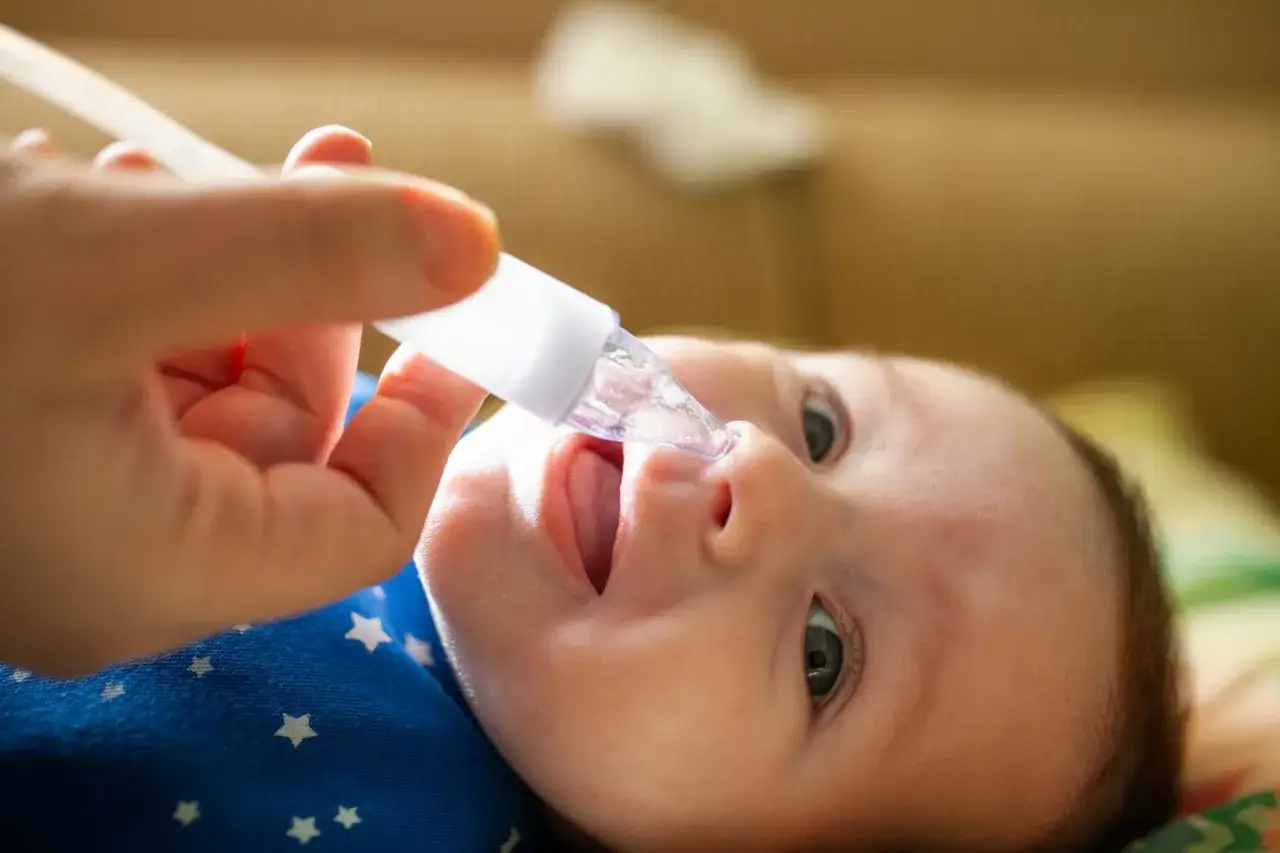 Un beb&eacute; recibe un aspirador nasal, un m&eacute;todo para aliviar la congesti&oacute;n, &uacute;til entre los remedios caseros para la tos en beb&eacute;s.