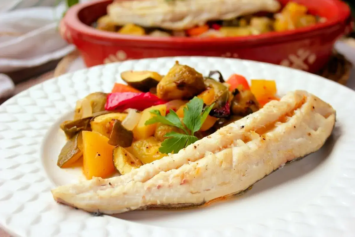 Un plato con pescado blanco y verduras asadas. Un entrante de primero crema de verduras y de segundo este delicioso pescado.