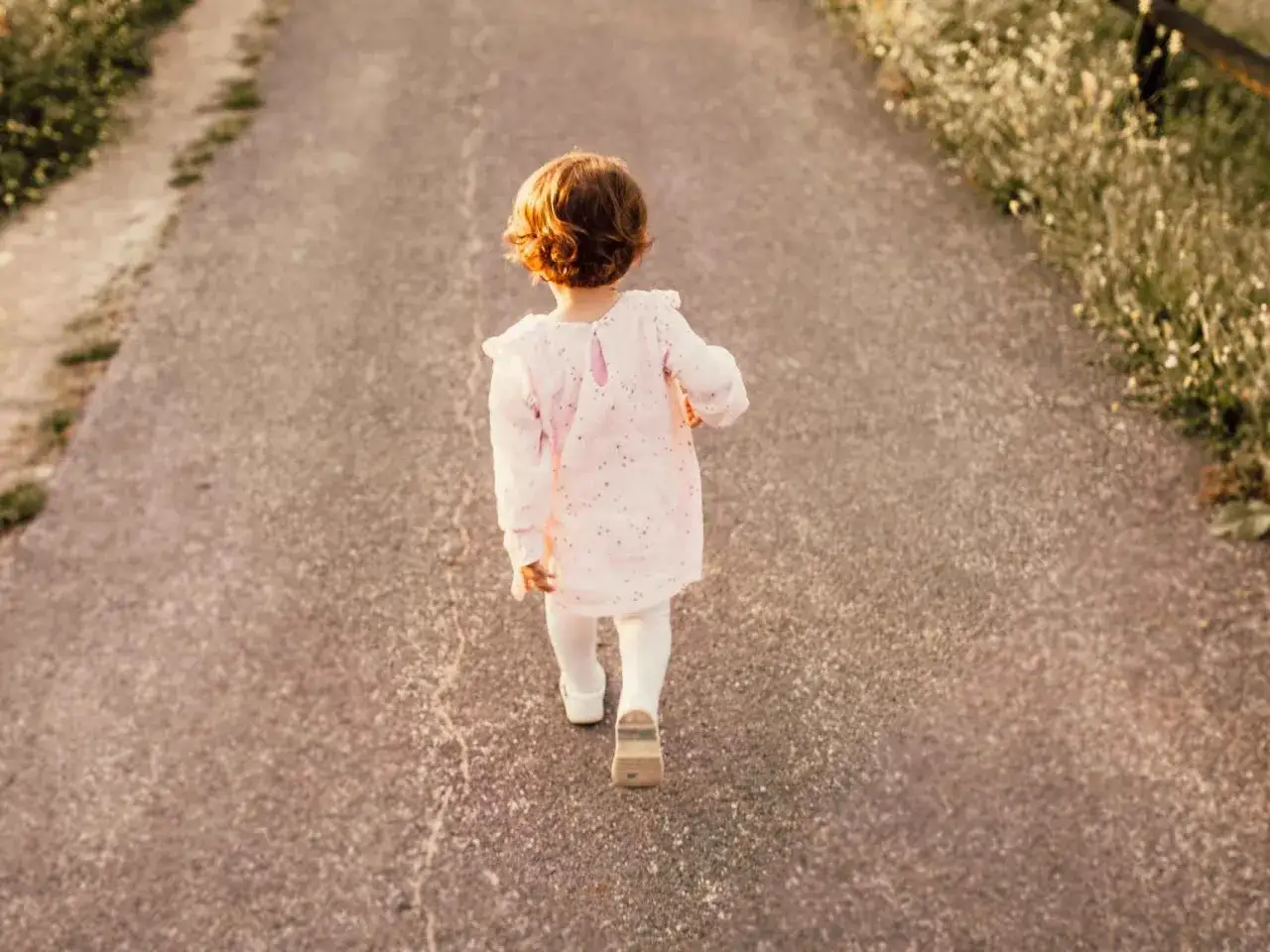 Ni&ntilde;a con vestido rosa camina por un sendero. Su nombre, Arlet, evoca la pureza y la inocencia de este momento.