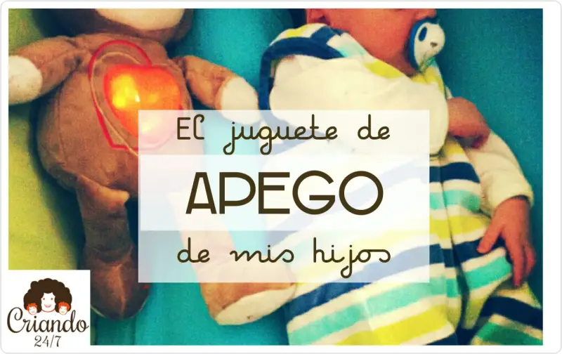 Un peluche con un corazón brillante, un bebé envuelto en mantas a rayas. El juguete de apego favorito de mis hijos.